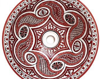May include: A white ceramic sink with a red and black geometric design. The sink has a round shape and a central drain hole.