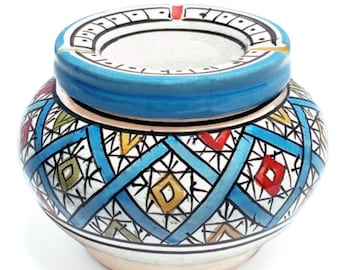 May include: A blue and white ceramic ashtray with a geometric pattern. The ashtray has a round top and a wide base.