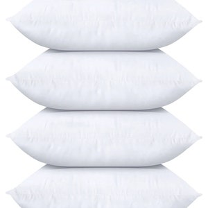 May include: Four white pillowcases stacked on top of each other. The pillowcases are made of a soft, smooth fabric.