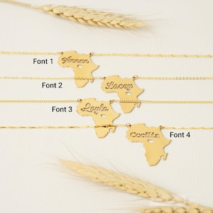 May include: Four gold-colored necklaces featuring a pendant shaped like the continent of Africa. Each pendant has a cutout name and a small heart shape. The names Annan, Lacey, Layla, and Cecilia are displayed with labels Font 1, 2, 3, and 4.