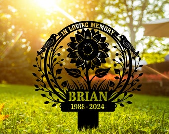 May include: Black metal garden stake with a sunflower design and the text "In Loving Memory" and "Brian 1988-2024".