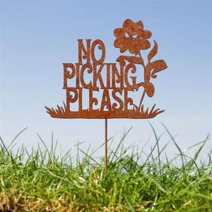 May include: A rusty metal garden stake with the words "NO PICKING PLEASE" and a grumpy flower design. The sign is set in a grassy area with a blue sky background. A decorative garden accent.