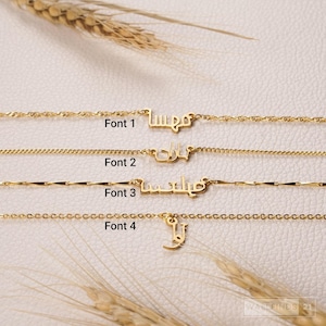 May include: Four gold-toned necklaces featuring custom Arabic name pendants, each displayed with a distinct chain style and font labeled Font 1, Font 2, Font 3, and Font 4. The necklaces are arranged horizontally, showcasing varied link designs and script styles.