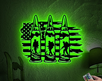 May include: A green and black wall light featuring a silhouette of three soldiers walking in front of an American flag. The light is controlled by a remote control with multiple buttons.