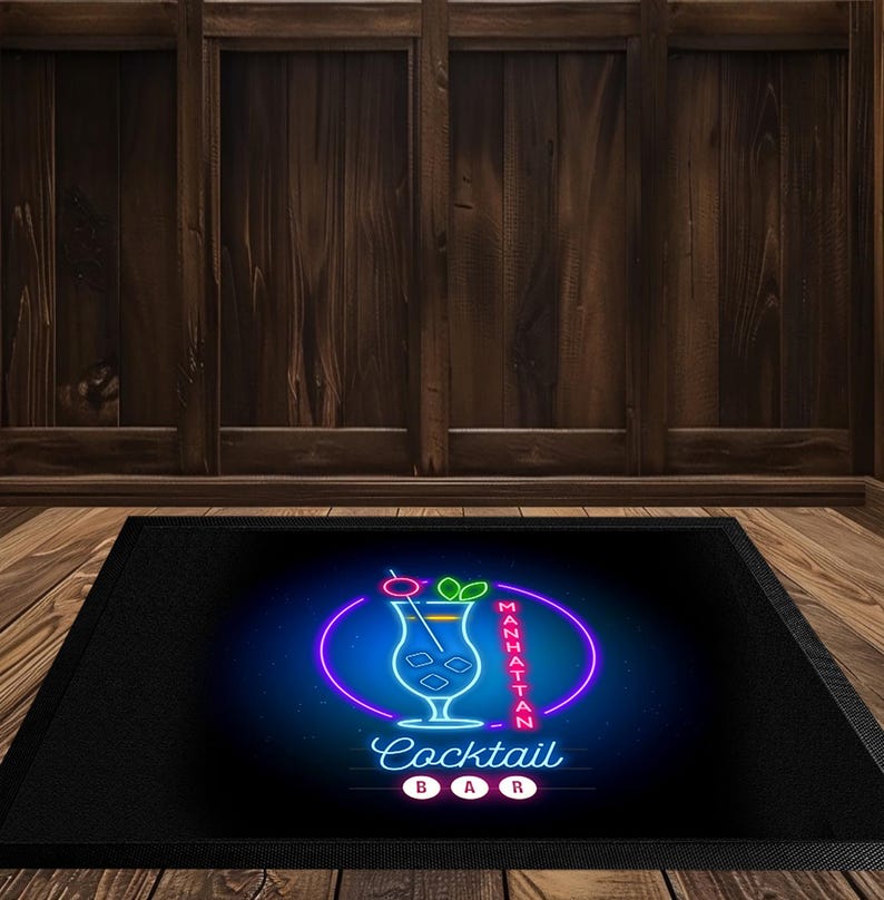 May include: Black rectangular mat with a neon sign design. The sign features a cocktail glass with a cherry and lime, surrounded by a purple oval and the words "Manhattan Cocktail Bar."