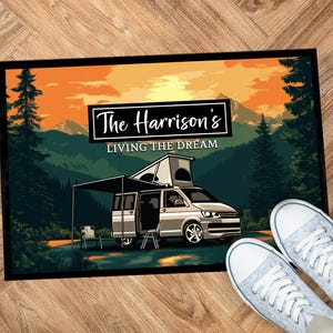 Könnte beinhalten: Eine Fußmatte mit einer Sonnenuntergangsszene und einem Wohnmobil. Der Text auf der Fußmatte lautet "The Harrison's Living the Dream".
