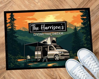 Puede incluir: Una alfombra de bienvenida con una escena de puesta de sol y una autocaravana. El texto en la alfombra dice "The Harrison's Living the Dream".