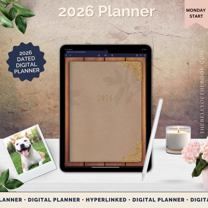 May include: A digital planner for 2026 displayed on a tablet. The planner has a tan cover with gold corner accents and the year 2026 printed on it. A white stylus and a lit candle are next to the tablet. The words "2026 Planner" are at the top.