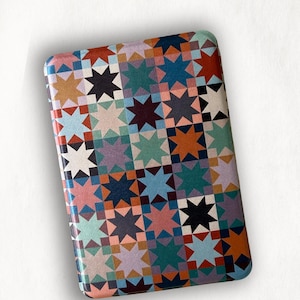 May include: A rectangular protective case featuring a repeating geometric star pattern in shades of orange, teal, navy blue, pink, lavender, and white. The text @EMOTIONALSUPPORTCASES is printed in small black letters at the bottom center of the case.
