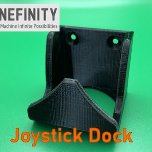 May include: A black 3D printed wall mount for a joystick, with the text "Joystick Dock" printed below. The mount has two holes for mounting screws.