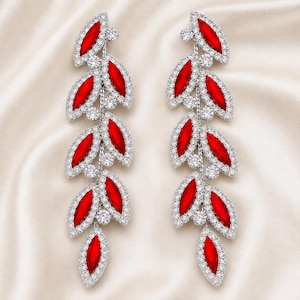 May include: A pair of long, dangling earrings featuring a cascading leaf-like design. Each earring is composed of multiple marquise-cut red stones set in silver-toned metal, surrounded by small, clear, round pavé-set crystals in a vine-like arrangement.