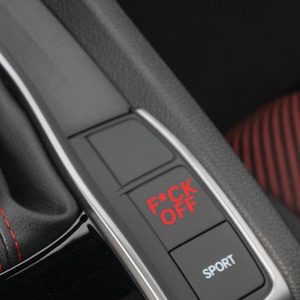 Puede incluir: Un interior de coche negro con un botón rojo que dice "F*CK OFF" y un botón negro que dice "SPORT".