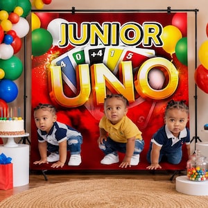 May include: A birthday party scene with a backdrop featuring the words "JUNIOR UNO" and card illustrations. Three toddlers are in front of the backdrop. Balloons in various colours and a cake with candles are also present.