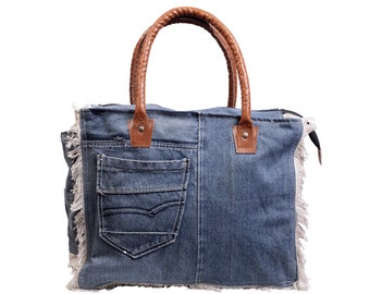 May include: A blue denim tote bag with brown leather handles and a large front pocket. The bag has a frayed edge.