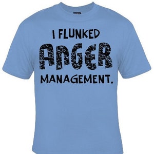 May include: Light blue t-shirt with black text that reads "I flunked anger management."