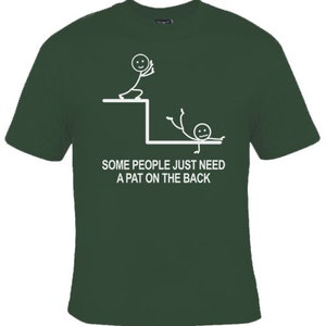 May include: A green t-shirt featuring a white stick figure design. The design depicts one stick figure pushing another stick figure off a ledge. The text on the shirt reads "Some people just need a pat on the back."