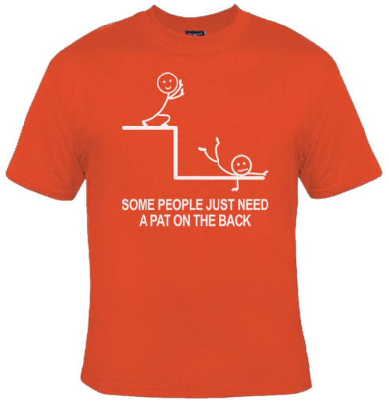 May include: Orange t-shirt featuring a white stick figure design. The design depicts one stick figure pushing another stick figure off a ledge. The text reads "Some people just need a pat on the back."