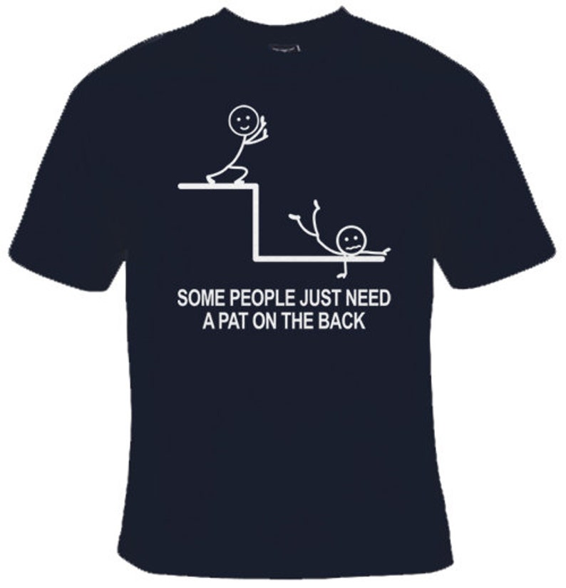 May include: A dark blue t-shirt featuring a white stick figure design. The design depicts one stick figure pushing another stick figure off a ledge. The text on the shirt reads "Some people just need a pat on the back."