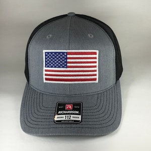 May include: Gray and black trucker hat with an American flag patch and the text "EST. 1970 RICHARDSON. ORIGINAL 112 TRUCKER ADJUSTABLE" on the front.