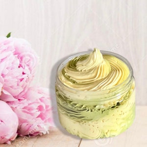 May include: A clear jar filled with a green and white whipped body butter. The butter is swirled in a decorative pattern.