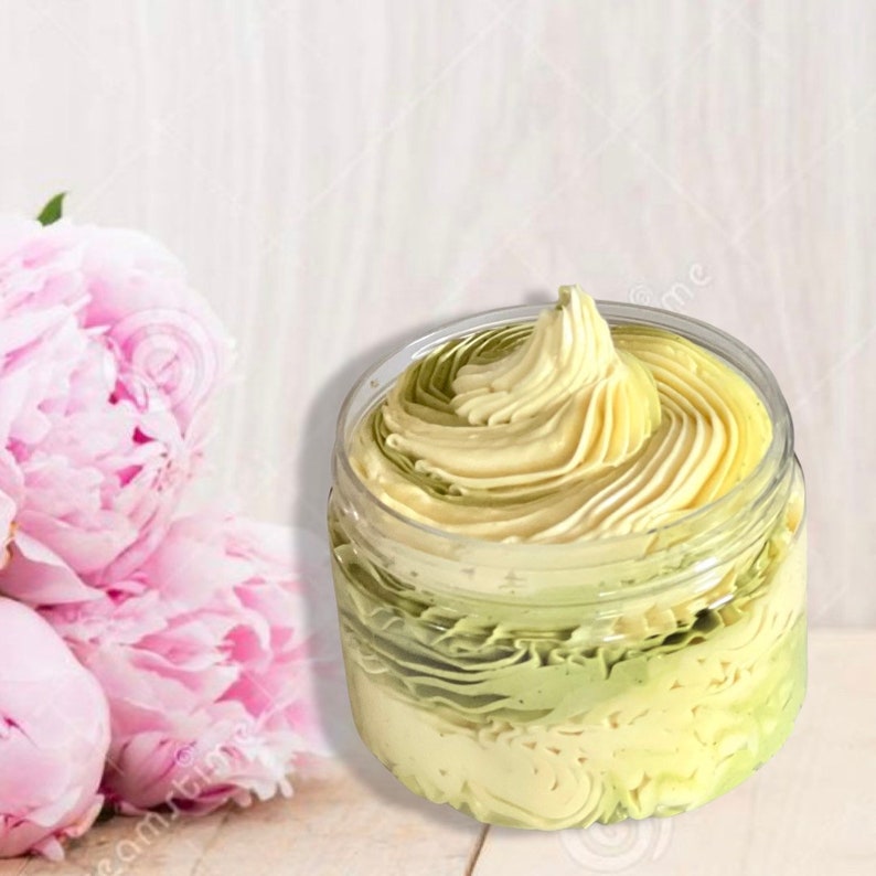 May include: A clear jar filled with a green and white whipped body butter. The butter is swirled in a decorative pattern.