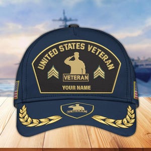 May include: Navy blue baseball cap with a gold and black United States Veteran patch. The patch includes the text "UNITED STATES VETERAN", a saluting silhouette, and space for a name. Gold laurel leaves and American flags adorn the cap.