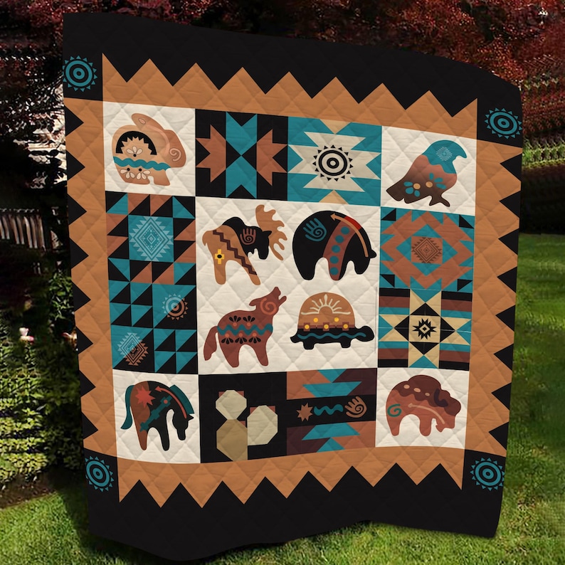 May include: A quilted blanket with a Native American design. The blanket features a patchwork of squares with various animal and geometric patterns in shades of brown, teal, and black. The border is black with a brown zigzag pattern.