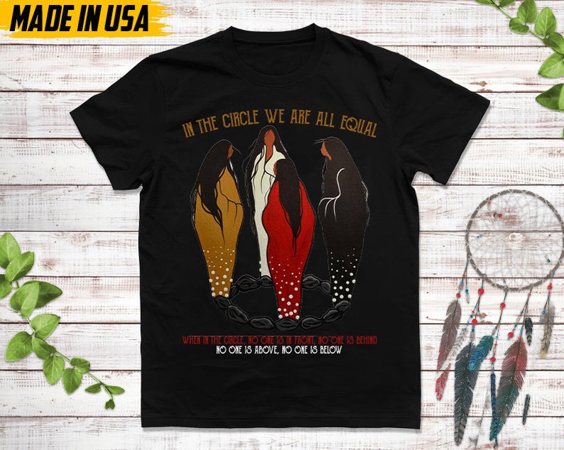 Puede incluir: Camiseta negra con el texto "IN THE CIRCLE WE ARE ALL EQUAL" y una ilustraci&oacute;n de tres figuras en c&iacute;rculo. El texto "WHEN IN THE CIRCLE, NO ONE IS IN FRONT, NO ONE IS BEHIND, NO ONE IS ABOVE, NO ONE IS BELOW" tambi&eacute;n est&aacute; impreso en la camiseta. "MADE IN USA" est&aacute; impreso en la parte superior izquierda.