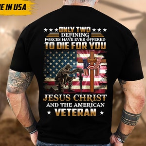 May include: Black t-shirt featuring a design with the American flag, a cross, and a kneeling soldier. The text reads "ONLY TWO DEFINING FORCES HAVE EVER OFFERED TO DIE FOR YOU JESUS CHRIST AND THE AMERICAN VETERAN". The words "MADE IN USA" are also visible.