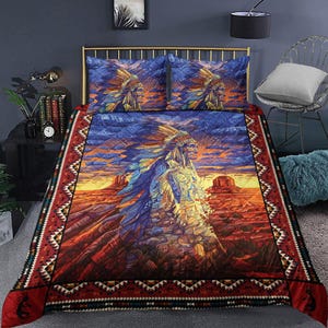 May include: A quilt set featuring a Native American chief in a headdress, set against a desert landscape with a sunset sky. The bedding set includes a quilt and two pillowcases. The quilt has a red border with geometric patterns.