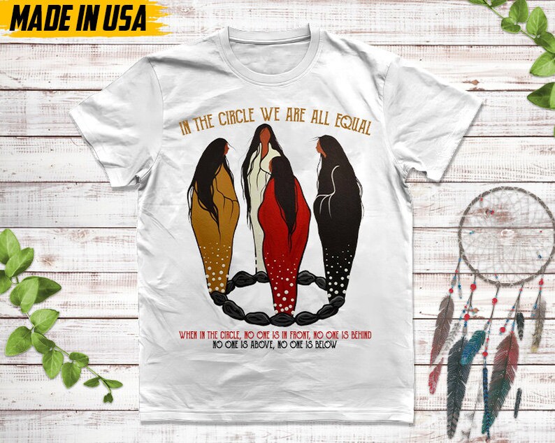 Puede incluir: Camiseta blanca con el texto "IN THE CIRCLE WE ARE ALL EQUAL" y una ilustraci&oacute;n de cuatro figuras en un c&iacute;rculo. El texto "WHEN IN THE CIRCLE, NO ONE IS IN FRONT, NO ONE IS BEHIND, NO ONE IS ABOVE, NO ONE IS BELOW" tambi&eacute;n est&aacute; impreso en la camiseta. "MADE IN USA" est&aacute; impreso en la parte superior izquierda.