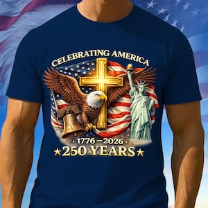 May include: Navy blue t-shirt featuring a patriotic design with an eagle, cross, Statue of Liberty, and American flag. Text reads "CELEBRATING AMERICA" and "1776-2026 *250 YEARS*".