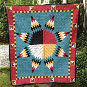 May include: A colorful quilt with a large star design. The star is divided into quadrants of black, red, white, and yellow. The quilt has a teal background and a red border with geometric patterns. The quilt is approximately 70 inches by 80 inches.