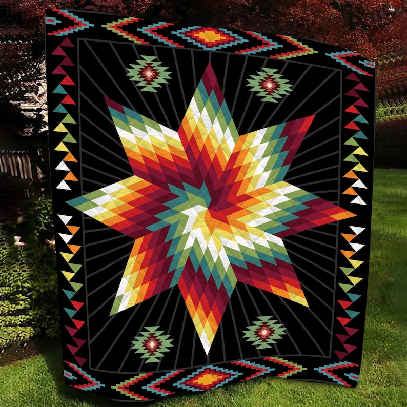 K&ouml;nnte beinhalten: Eine schwarze Steppdecke mit einem farbenfrohen Sternenmuster in Rot, Orange, Gelb, Gr&uuml;n und Wei&szlig;. Der Stern steht im Mittelpunkt, vor einem schwarzen Hintergrund mit geometrischen Mustern und Linien. Das Design der Steppdecke ist von indianischer Kunst inspiriert.