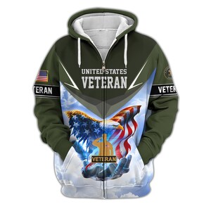 Może przedstawiać: Bluza z kapturem zapinana na zamek błyskawiczny z patriotycznym wzorem. Prz&oacute;d przedstawia orła, amerykańską flagę i słowa "United States Veteran". Rękawy mają amerykańską flagę i słowo "Veteran". Tło to zachmurzone niebo.