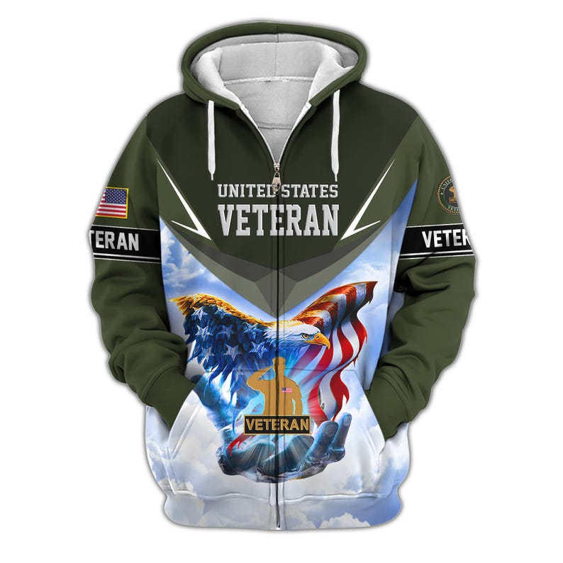 Może przedstawiać: Bluza z kapturem zapinana na zamek błyskawiczny z patriotycznym wzorem. Prz&oacute;d przedstawia orła, amerykańską flagę i słowa "United States Veteran". Rękawy mają amerykańską flagę i słowo "Veteran". Tło to zachmurzone niebo.