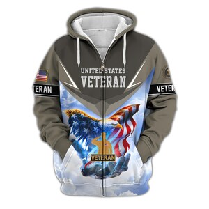 Może przedstawiać: Bluza z kapturem zapinana na zamek błyskawiczny z patriotycznym wzorem. Prz&oacute;d przedstawia orła, amerykańską flagę i napisy "UNITED STATES VETERAN". Rękawy mają amerykańską flagę i napis "VETERAN" w kolorze białym. Bluza z kapturem jest gł&oacute;wnie oliwkowozielona, szara i biała.