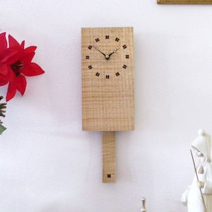 Wooden Wall Clock. Pendulum Wall Clock in ripple sycamore with inlaid walnut and sycamore squares. 150 Series - Rectangle/Striped Squares.