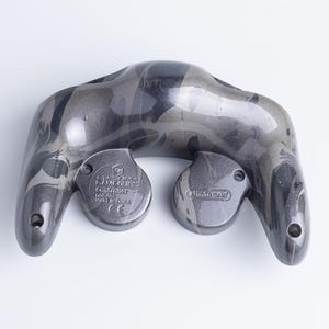 May include: A grey and black marbled video game controller shell viewed from the back. The plastic casing features a smooth, glossy finish with a swirling pattern. Embossed text on the back includes Nintendo GameCube Controller and Made in China.
