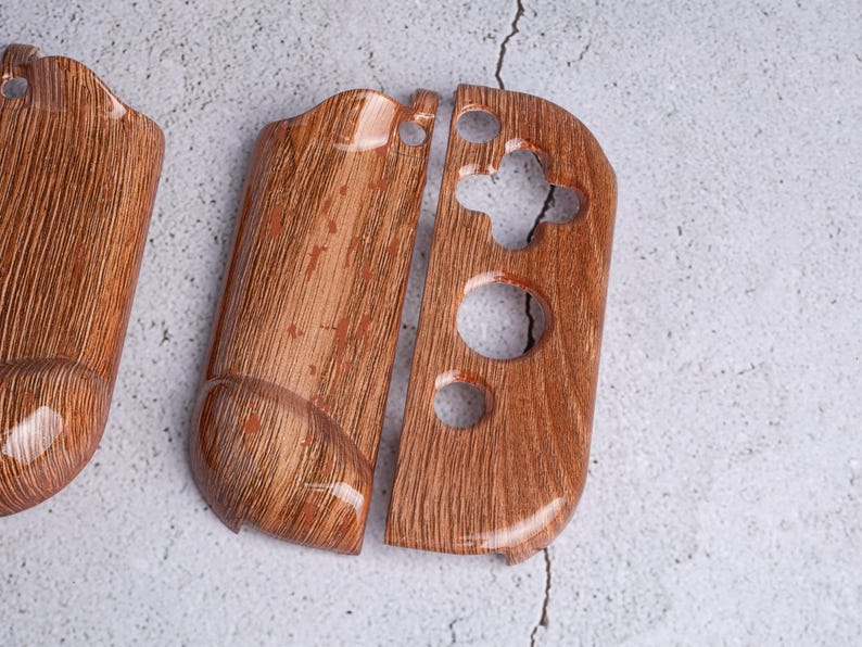 May include: Wooden-textured Switch Joy-Con controller shells. The shells are a warm brown color with a wood grain pattern. The design includes button and joystick cutouts, and a glossy finish.