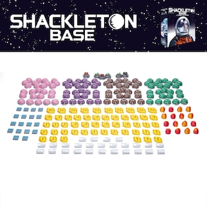 May include: A board game called "Shackleton Base" with an array of game components. These include pink, purple, brown, and green dome-shaped tokens, blue and white square tiles, and gold and silver coin-like tokens.