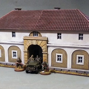 Peut inclure: Un bâtiment blanc avec un toit en tuiles rouges et une grande porte cintrée. Une jeep militaire est garée devant le bâtiment avec trois personnages debout à proximité.