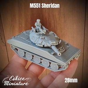Puede incluir: Un modelo de plástico gris de un tanque M551 Sheridan con un miembro de la tripulación en la torreta. El tanque está a escala de 28 mm y está hecho por Eskice Miniature.