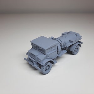 Puede incluir: Un modelo de camión cisterna militar de plástico gris. El camión tiene una cabina con un parabrisas y un gran tanque de combustible en la parte trasera.