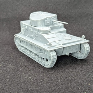 May include: A small, grey model tank with a turret and a gun. The tank has detailed tracks and a rectangular body. The model is made of a solid material and sits on a dark surface. A miniature replica of a military vehicle.