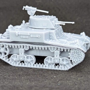 May include: A grey plastic model of a light tank with a machine gun turret and tracks.