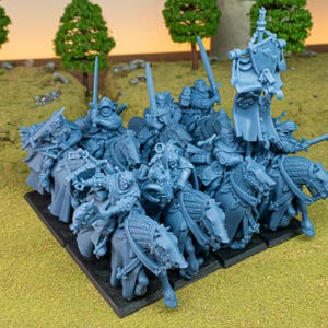 Puede incluir: Un grupo de figuras en miniatura de color azul claro que representan caballeros montados. Cada caballero está armado con una espada y un escudo, y los caballos están blindados. Las figuras están dispuestas sobre una base negra, lo que sugiere un juego de mesa o un objeto de colección.