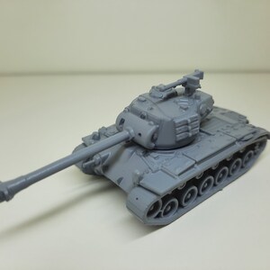 May include: A gray plastic model of a tank with a long barrel and a detailed turret. The tank has a series of wheels on the side.