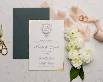 May include: A wedding invitation with gold accents and a white background. The invitation features a crest with the date "26 August 2023" and the names "Cense & Kemal". The text reads "BU MUTLU GÜNCEDE BİZLERLE OLMANIZDAN MUTLULUK DUYACAGIZ" and "AKGÜL VE ÖZBEY AİLELERİ". The invitation also includes the details of the wedding ceremony and reception.