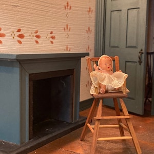 Handcrafted miniature high chair with baby
